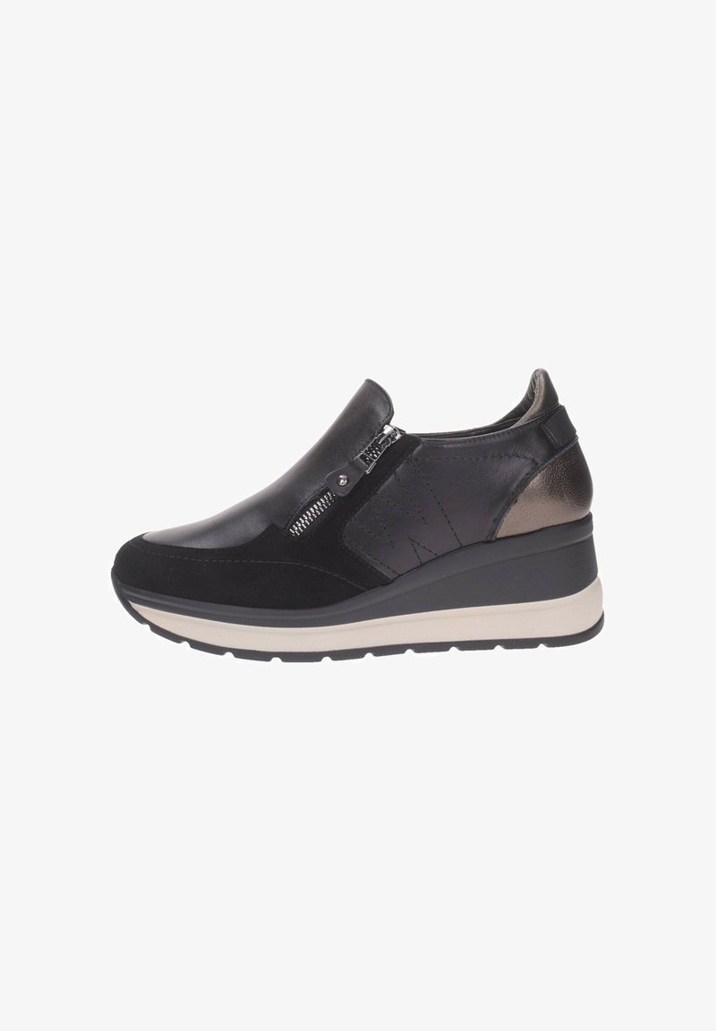 Zapato negro de tipo slip-on con materiales de cuero y ante, que cuenta con un cierre lateral, puntera redondeada y una suela de cuña con acentos beige en contraste.