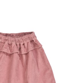 Vaaleanpunainen corduroykangas hame, jossa on röyhelövyötärö ja joustava nappi, joka tarjoaa vaakasuuntaisia uurteita ja levenevän muodon.