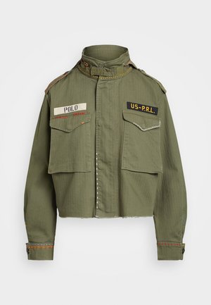 Veste militaire courte vert olive avec col montant, deux poches à rabat à l'avant, écussons "POLO" et "US-PRL", et coutures décoratives.