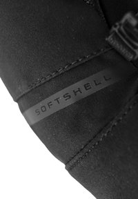 Tela softshell negra con una textura suave, que presenta una costura cosida y una etiqueta negra mate que dice "SOFTSHELL."
