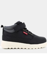 Sneaker nere alte con finitura opaca, strap in velcro, lacci tondi e suola in gomma bianca. Presenta un piccolo etichetta rossa Levi's.