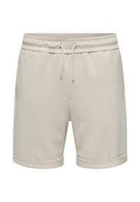 Pantalones cortos de algodón beige, con una cintura elástica y cordones, bolsillos laterales y bordes doblados. Tela suave y texturizada.