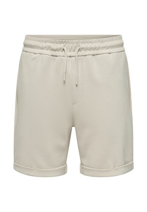 Pantalones cortos de algodón beige, con una cintura elástica y cordones, bolsillos laterales y bordes doblados. Tela suave y texturizada.