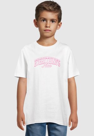 Hvit bomull t-skjorte med rosa teksten "EVERYTHING'S Nice". Korte ermer, rund hals, standard passform. Brukt med blå denimshorts.