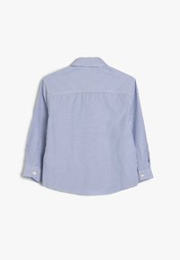 Camisa de manga larga a rayas azul y blanca con cuello, puños abotonados y dobladillo curvado. Fabricada con un tejido ligero.