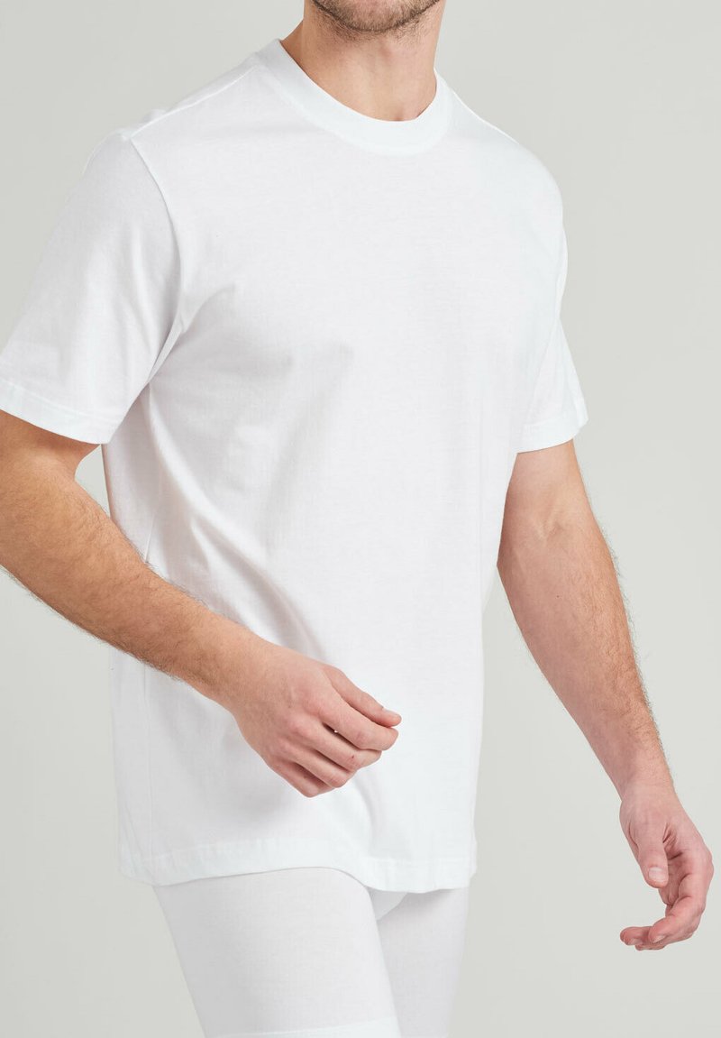 White crew neck t-shirt, short sleeves, made of soft cotton. Features a relaxed fit with straight hem, minimal seams, and smooth texture.