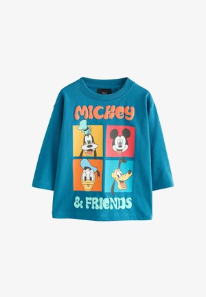Teal puuvillane T-särk, millel on multikategelased: Mickey Mouse, Donald Duck, Goofy ja Pluto. Plokktähtedega on kirjas "MICKEY & FRIENDS."