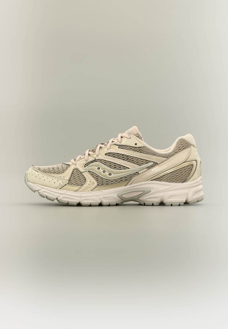Chaussure de course beige clair avec panneaux en mesh, surpiqûres synthétiques, fermeture à lacets et semelle en caoutchouc texturée, vue de profil sur fond neutre.