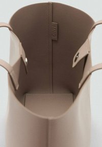Beige Leder-Tote mit weiter Öffnung und rundem Design. Verfügt über eine Innentasche und ein eingeprägtes Markenlogo an der inneren Naht.