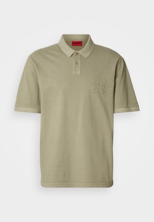 Khaki polo shirt with a collar, short sleeves, and embroidered "HUGO" logo on the left chest. Smooth cotton material, minimalistic design.