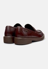 Burgunderrote Leder-Loafer mit Brogue-Details, rundem Zeh und einer strukturierten dunkelbraunen Plateausohle. Leichtes Design mit weichen Kanten.