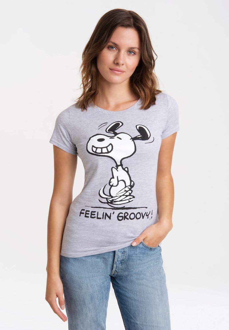 T-shirt en coton gris avec un graphique de personnage de dessin animé noir et le texte "FEELIN' GROOVY!" en dessous. Manches courtes, col rond.