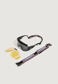 Occhiali sportivi neri con lenti scure, fascia regolabile con il marchio "CARRERA", e una lente gialla removibile inclusa.