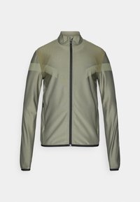 Ελαιόμορφο πράσινο αθλητικό σακάκι με φερμουάρ μπροστά, ανυψωμένο γιακά, υφή, μαύρες λεπτομέρειες και μακριά μανίκια. Διαθέτει στενή γραμμή.