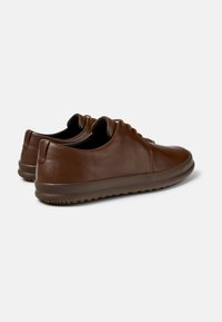 Brown leather shoes with smooth texture, rounded design, and lace-up front. Thick sole with grippy tread detail.