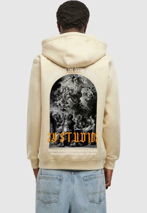 Felpa beige con graphic print sulla schiena, che rappresenta una scena in stile barocco con testo arancione e white. Tessuto morbido, vestibilità standard.