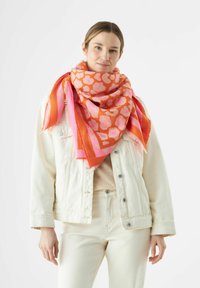 Bunte, übergroße Schal mit einem leuchtend orangefarbenen Grund, rosa Leopardenflecken und gestreiften Akzenten in Pink und Orange, gefertigt aus weichem Stoff.