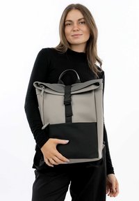 Grau und schwarz Roll-Top-Rucksack mit matter Oberfläche, Reißverschlusstasche, verstellbaren Trägern und einem oberen Griff für einfachen Transport.