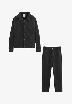 Veste en polaire pelucheuse gris foncé avec col, boutons à l'avant et poches latérales, associée à un pantalon fuselé assorti avec bouton à l'avant et poches.