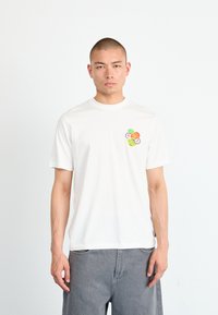 White cotton t-shirt with a round neckline and short sleeves, featuring a colorful front pocket design of stylized fruit illustrations.