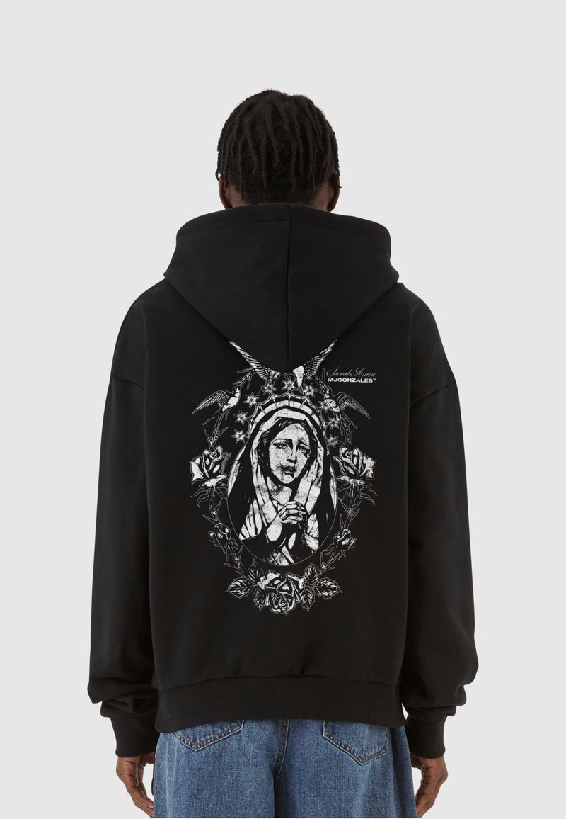 Zwarte hoodie met een grote witte afbeelding van een figuur omringd door rozen. Bevat een capuchon met trekkoord en geribbelde manchetten en zoom.