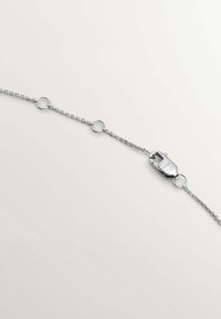 Pulsera de cadena de plata con eslabones ovalados y cierre de langosta, con textura metálica suave y diseño minimalista.