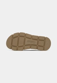 Rubber shoe sole with a textured, gripped surface. Features a flat design, segmented sections, and a light brown color.