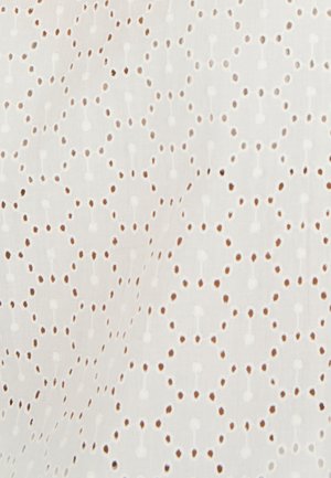 Tessuto bianco ricamato con un motivo di ritagli circolari e punti testurizzati disposti in un design geometrico.