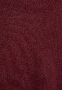 Viininpunainen neulepaita, jossa on teksturoitu kangas, resoripäinen pääntie ja pehmeä, lämmin ilme.