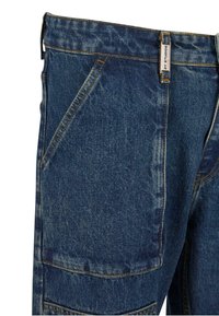 Denim pants in dark blue, featuring multiple pockets, stitched accents, and a high waistband. Displays a textured fabric with a distinct weave.