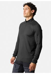 Pullover nero a maniche lunghe con colletto a mezza zip e tessuto testurizzato, dotato di tasca con zip sulla manica e design aderente.