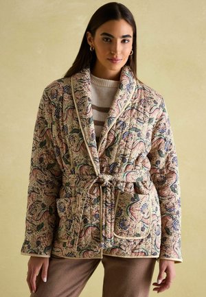 Gepatchter Bademantel mit Blumenmuster in Beige, der Farben wie Blau und Pink aufweist, mit einem Gürtel, Taschen und kontrastierenden Besätzen. Dekoratives Paisleymuster.