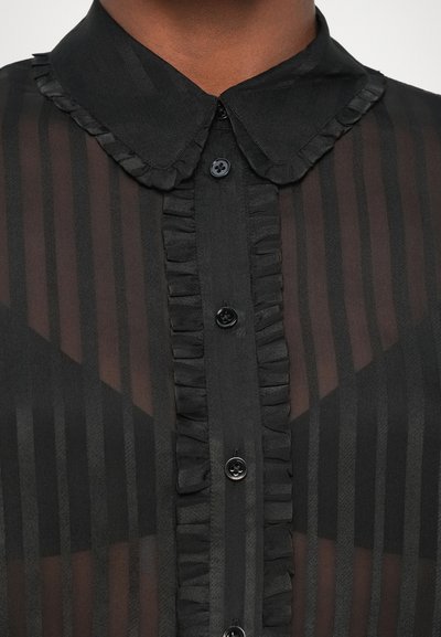 Schwarze durchsichtige Bluse mit Rüschenausschnitt, vertikal gestreiftem Muster und Knopfverschluss. Der strukturierte Stoff verleiht dem Design Tiefe.