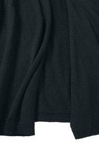 Mustaa neulosta, jossa on sileä pinta ja ribbihäntä. Kevyesti harjattu pinta pehmeillä taitteilla, joka yhdistää elegantin ja mukavan tyylin.