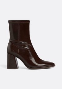 Bottines bordeaux à finition brillante, avec un bout pointu et un talon bloc structuré. Présente un matériau lisse et des détails de couture subtils.