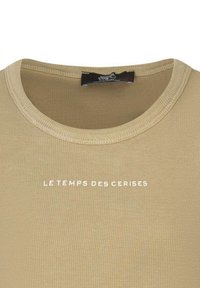 T-shirt beige à côtes avec un col rond et un texte blanc "LE TEMPS DES CERISES" centré sur la poitrine. En matériau mélange de coton.