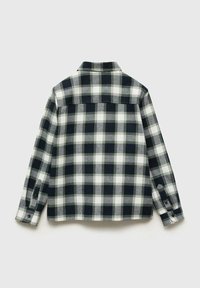 Camicia di flanella a quadri in bianco e nero con maniche lunghe, yoke frontale e polsini con bottone. Texture morbida e motivo a quadretti su tutta la superficie.