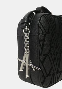 Borsa nera in pelle textured con un design geometrico, accessori in argento e una catena decorativa con accenti metallici angolari.