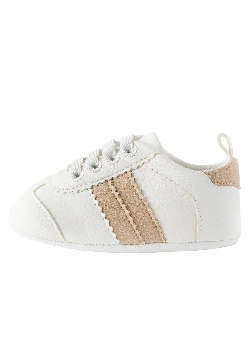 Zapato blanco hecho de material sintético con una suave franja beige y costura en ojal, con punta redondeada y cordones de tela.