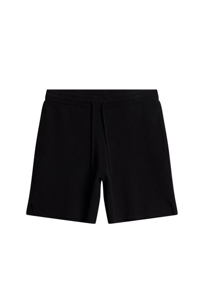 Svart shorts laget av mykt stoff med elastisk midje og snor. Har to sidelommer og en avslappet passform med splitt i kanten.