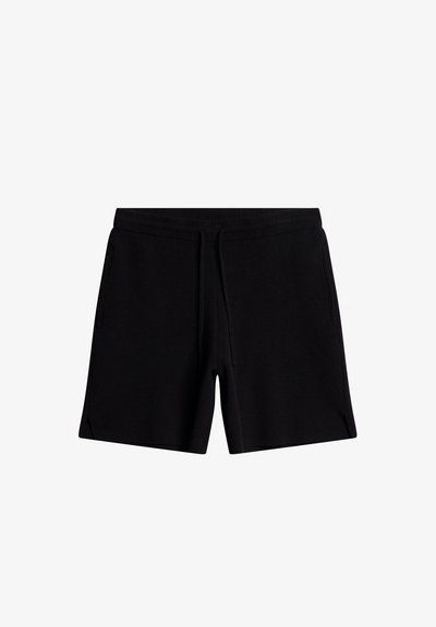 Black shorts made of soft fabric with an elastic waistband and drawstring. Features two side pockets and a relaxed fit with slits at the hem.