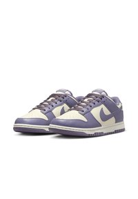 Purple and cream low-top sneakers with lace-up design, leather upper, perforated toe, textured sole, and subtle logo accents.