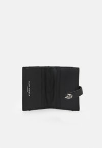 Czarny skórzany portfel o fakturowanym wykończeniu, z przegródkami na karty, srebrnym zapięciem i wytłoczonym nazwiskiem marki wewnątrz.