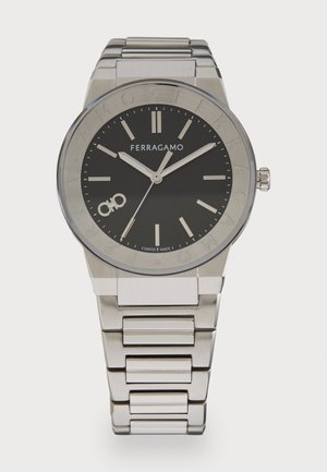 Silver-tone stainless steel watch with a black dial, prominent hour markers, and logo. Features a linked bracelet and round case.