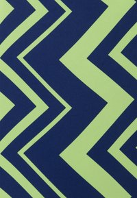 Motivo a zigzag di chevron alternati in ampie strisce verde lime e blu navy su una superficie tessile.