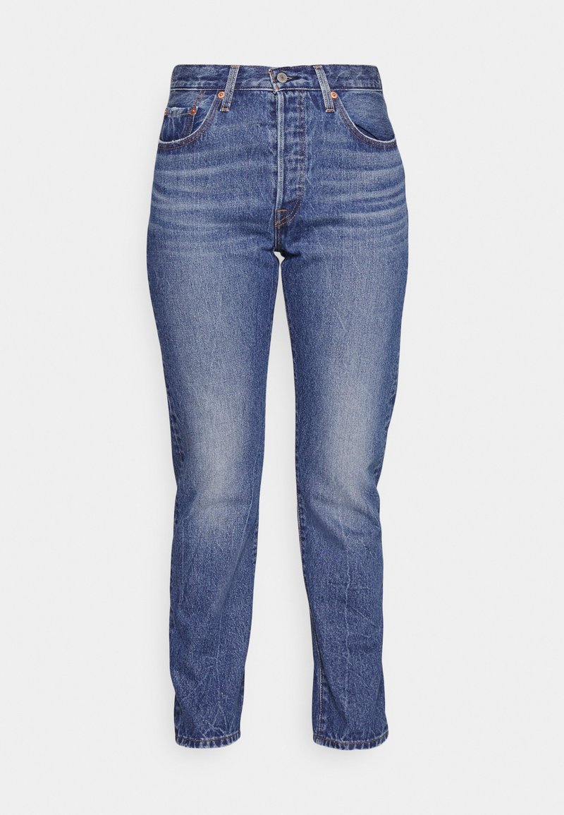 Jeans wykonane z denimu w ciemnoniebieskim kolorze, o klasycznym prostym kroju, wysokim stanie i subtelnych przetarciach. Posiadają szlufki na pasek oraz pięć funkcjonalnych kieszeni.