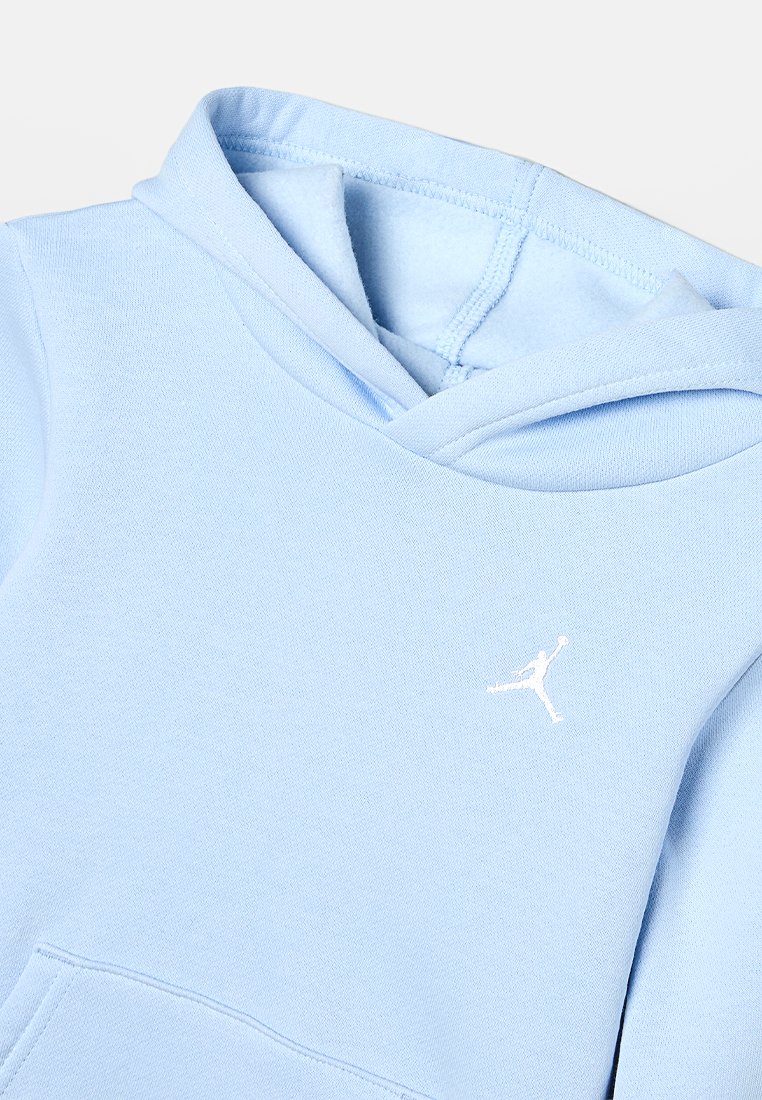 Haut à capuche bleu clair en tissu doux, doté d'une poche kangourou à l'avant, d'une capuche avec cordon de serrage et d'un petit logo Jordan blanc sur la poitrine.