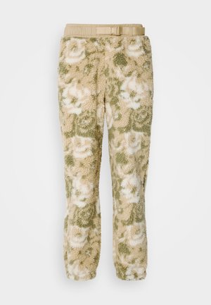 Pantalons en polaire avec une texture douce, arborant un motif floral en crème et vert. Équipés d'une taille élastique et d'une ceinture.
