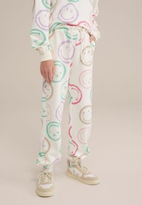 Vita sweatpants med färgglada smiley-ansikten i rosa, grönt, lila och beige. Elastisk midja med dragsko. Mjuk tygkvalitet.