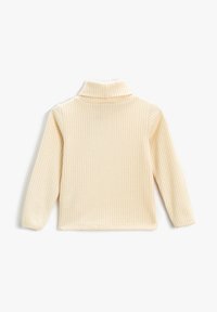 Cremefarvet ribbestrikket turtleneck sweater med lange ærmer, lagt fladt på en hvid baggrund.
